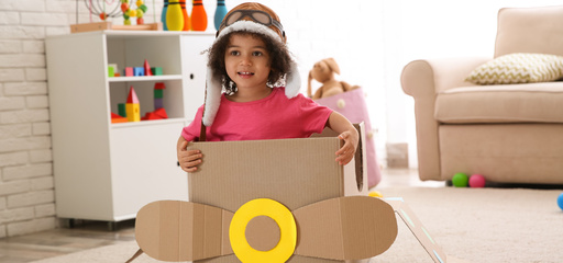 Cute african american toddler playing in a cardboard plane 